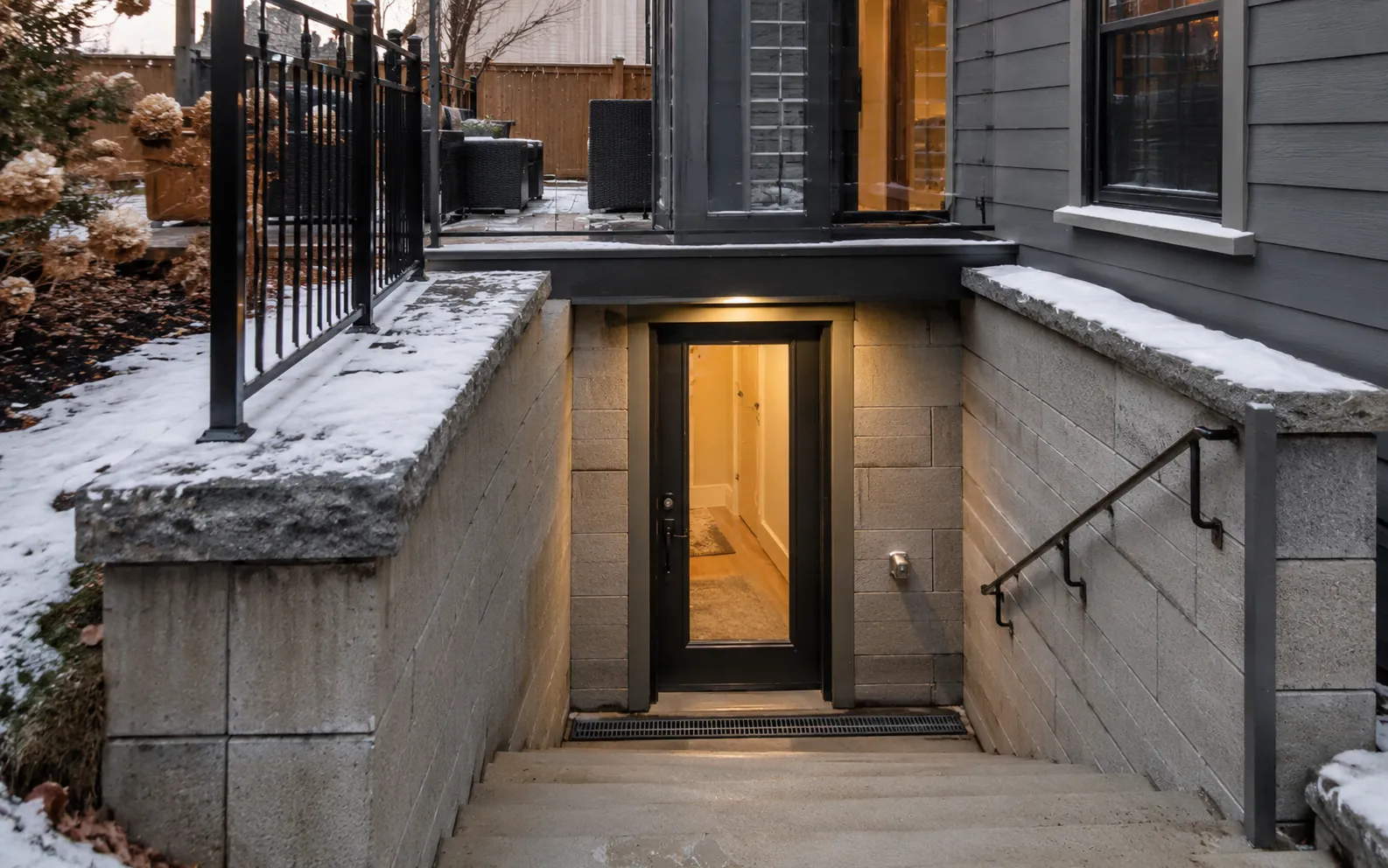 Basement walkout and separate entrance in Ottawa at winter twilight, code-compliant exterior stairs and railing