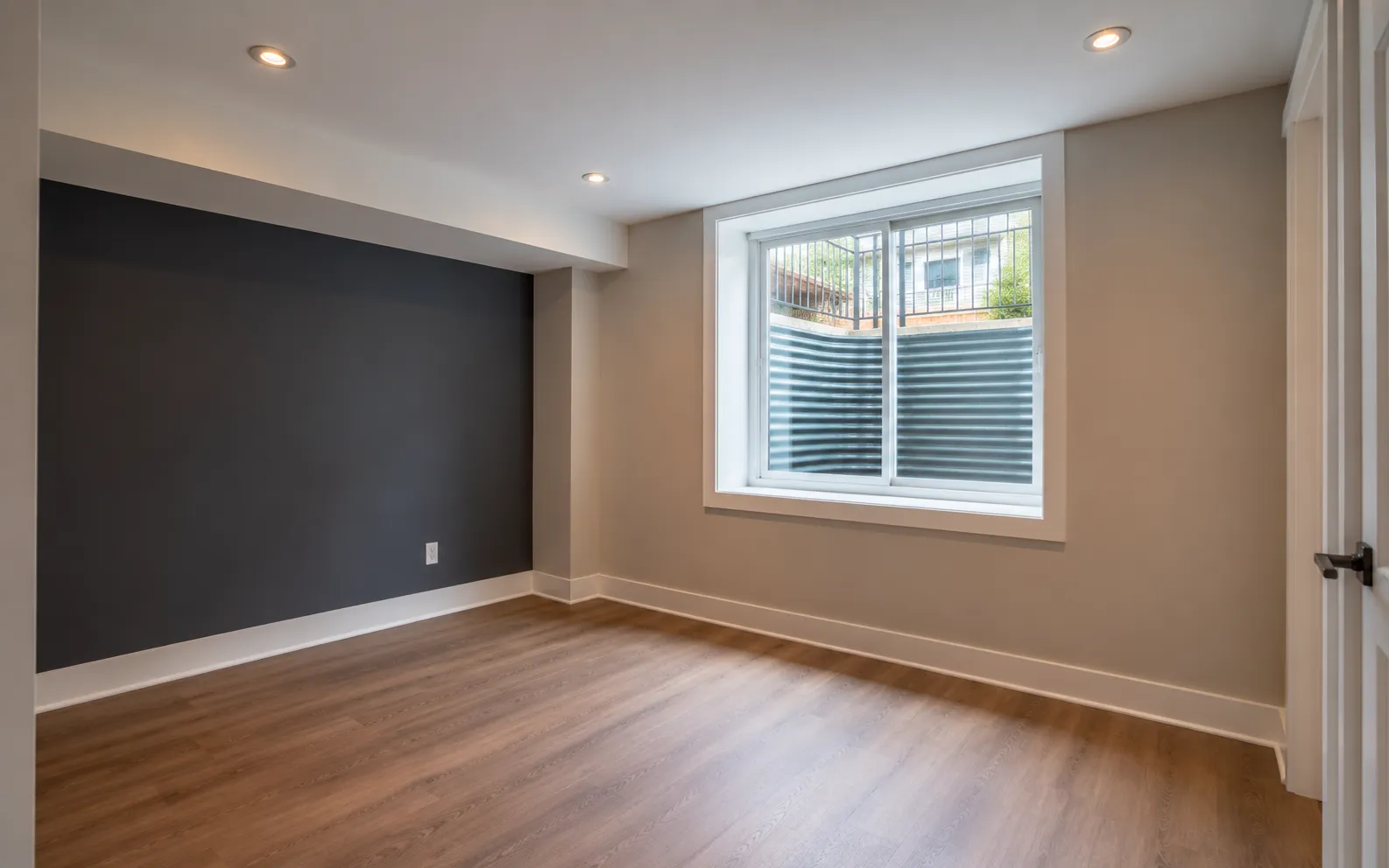 Bright finished Ottawa basement room lit by a code-sized egress window with a clear rescue opening